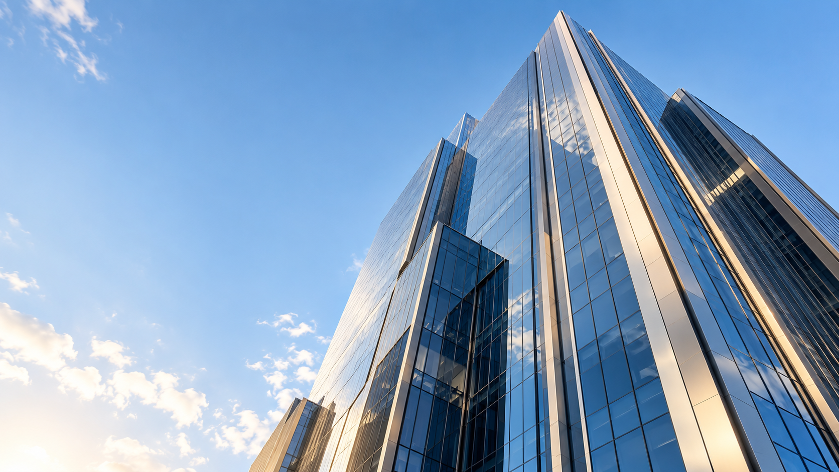Contemporary glass architecture reflecting the sky in warm daylight